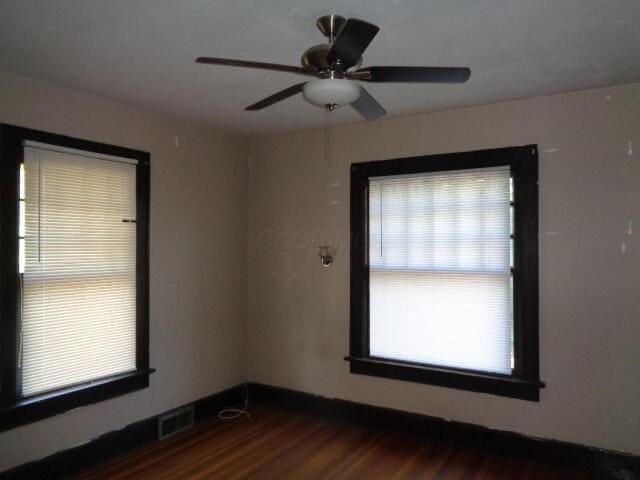 spare room with ceiling fan and dark hardwood / wood-style floors