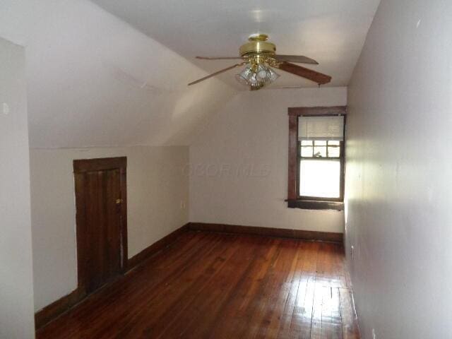 additional living space with ceiling fan, dark hardwood / wood-style flooring, and vaulted ceiling