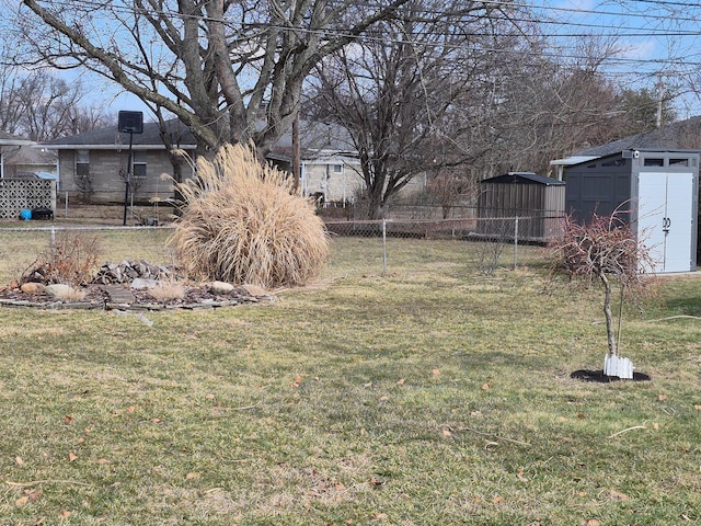 view of yard featuring an outbuilding, a storage unit, and fence