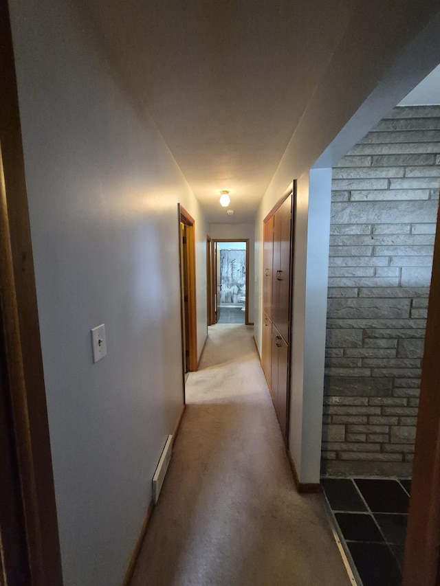 hall with a baseboard heating unit and light carpet