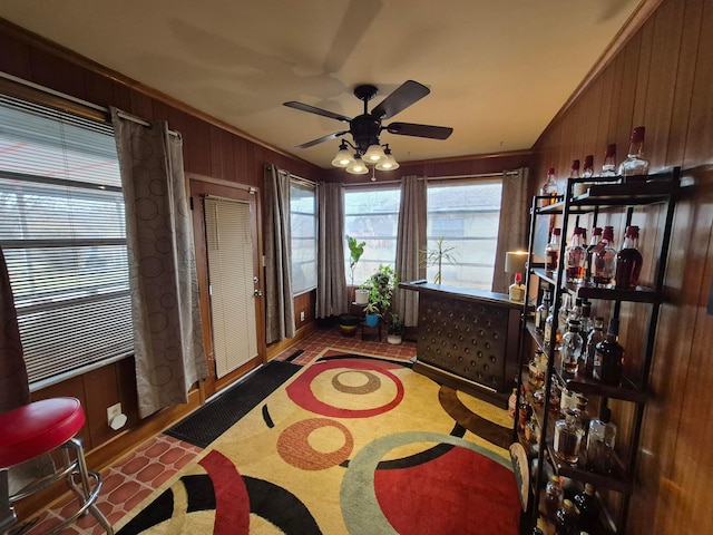 interior space featuring crown molding, wooden walls, and ceiling fan