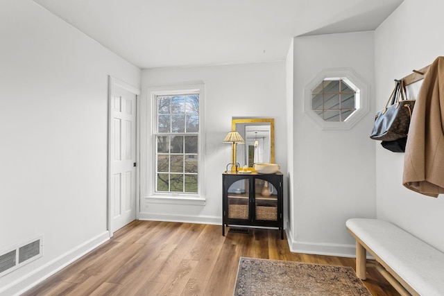 mudroom featuring baseboards, visible vents, and wood finished floors