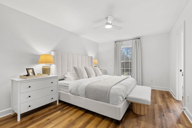 bedroom with wood finished floors, a ceiling fan, and baseboards