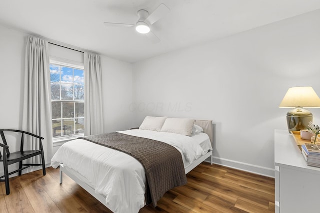 bedroom featuring a ceiling fan, baseboards, and wood finished floors