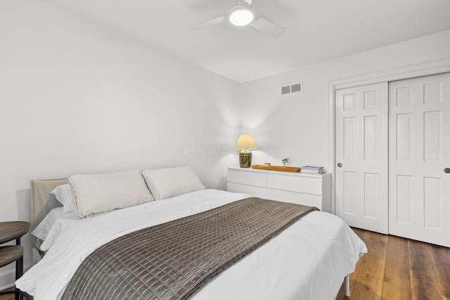 bedroom with a ceiling fan, wood-type flooring, visible vents, and a closet