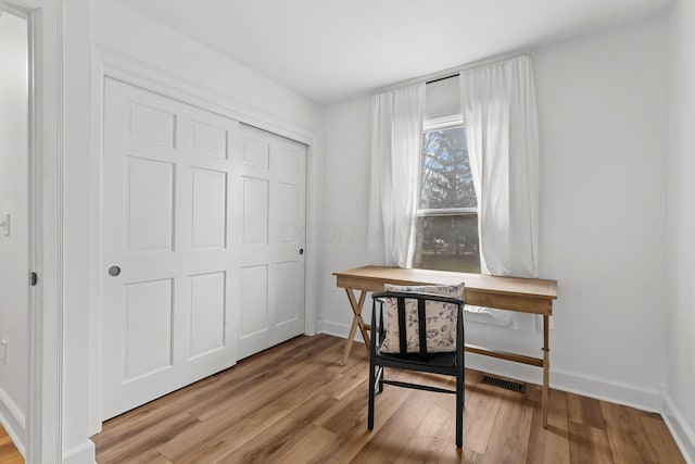 office featuring wood finished floors, visible vents, and baseboards