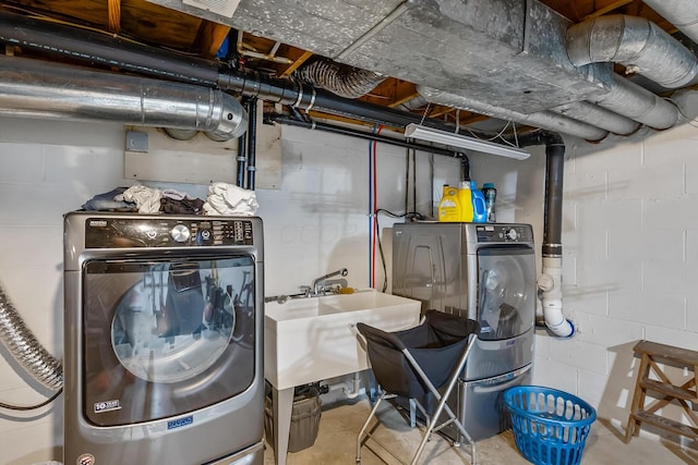 clothes washing area with washer and clothes dryer and sink