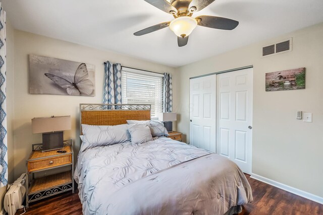 bedroom featuring dark wood-type flooring, ceiling fan, and a closet