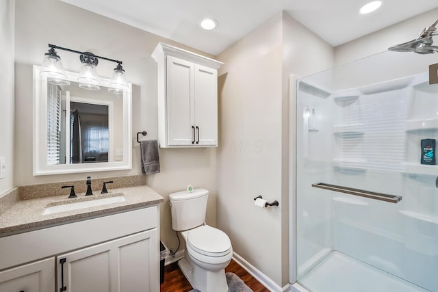 bathroom with vanity, wood-type flooring, an enclosed shower, and toilet