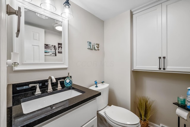 bathroom featuring vanity and toilet