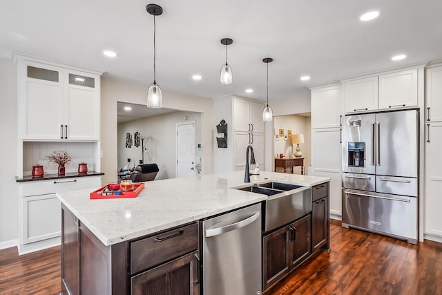 kitchen with dark wood-type flooring, sink, white cabinetry, hanging light fixtures, and stainless steel appliances