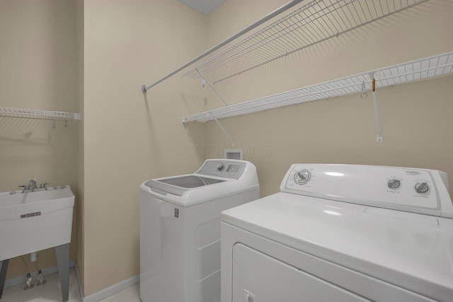 laundry room with washing machine and clothes dryer and sink