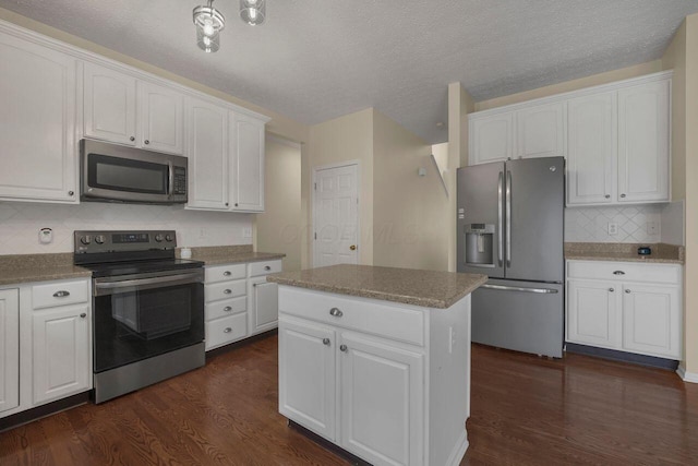 kitchen with stainless steel appliances, white cabinetry, and a kitchen island