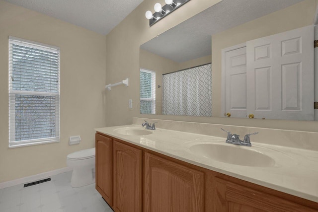 bathroom with vanity, walk in shower, a textured ceiling, and toilet