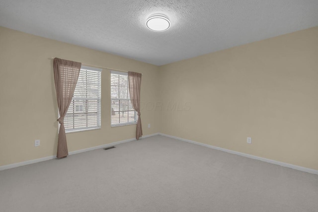 unfurnished room featuring carpet floors and a textured ceiling