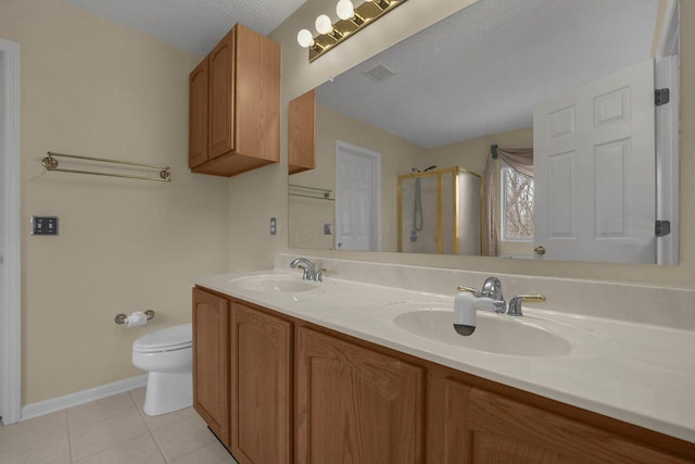 bathroom featuring a shower with shower door, tile patterned flooring, vanity, toilet, and a textured ceiling