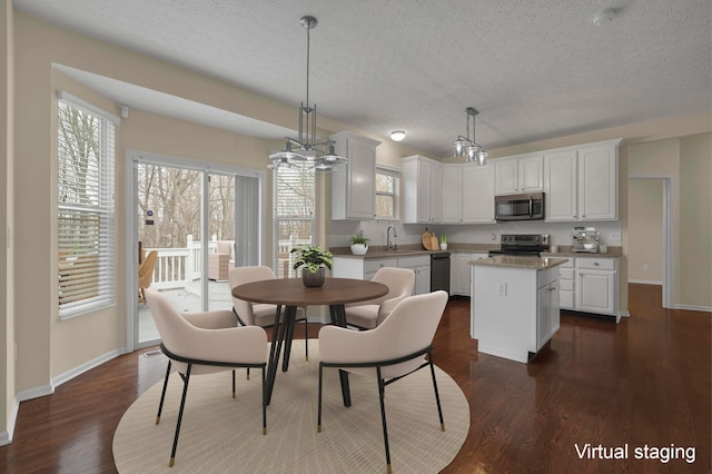 dining space featuring dark hardwood / wood-style flooring, sink, and a textured ceiling