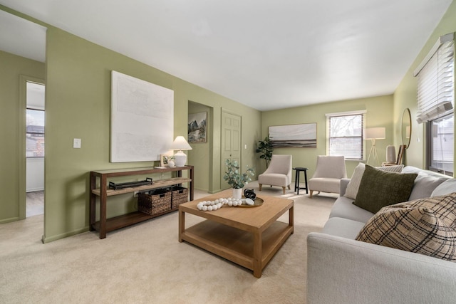 living area featuring baseboards and light colored carpet