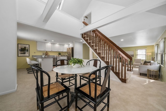 dining room with recessed lighting, light colored carpet, stairway, and baseboards