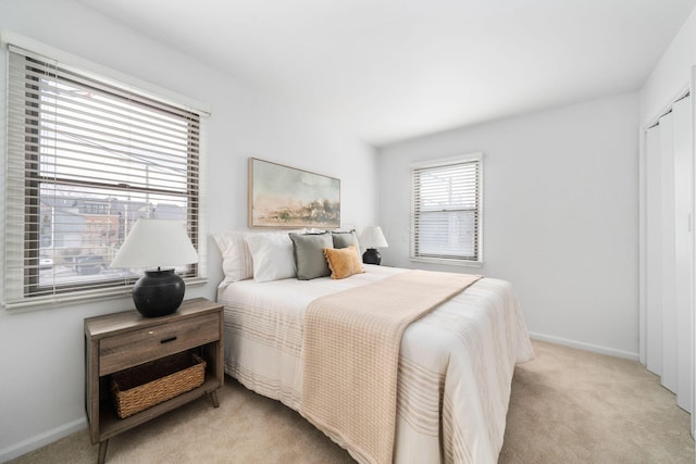 bedroom featuring light carpet and baseboards