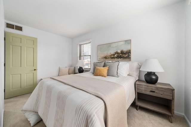 bedroom with baseboards, visible vents, and light colored carpet