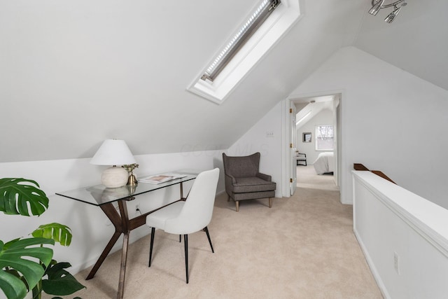 home office with light carpet and vaulted ceiling with skylight