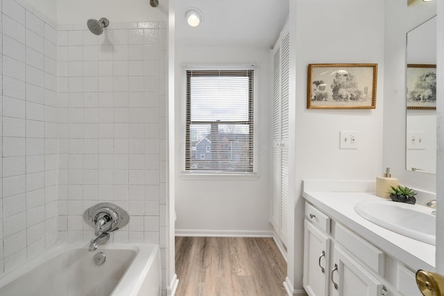 bathroom with baseboards, shower / washtub combination, wood finished floors, and vanity