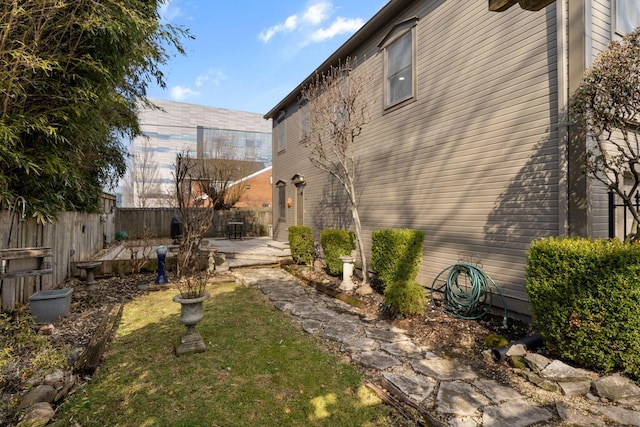 exterior space with a patio area, a fenced backyard, and a yard