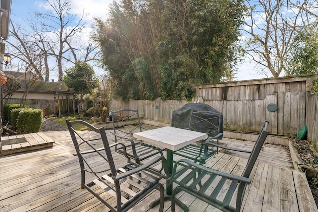 deck featuring outdoor dining area and a fenced backyard