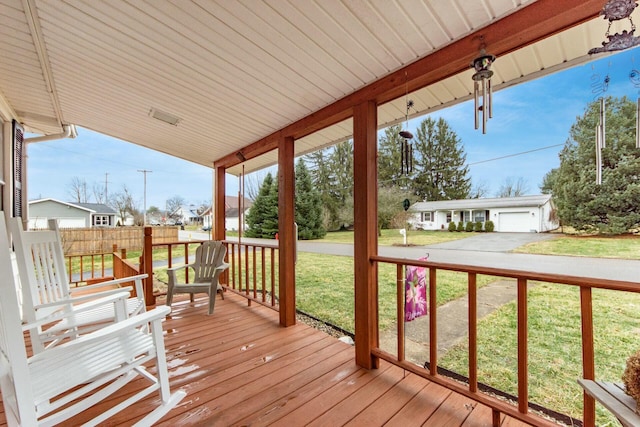 wooden terrace with a garage and a yard