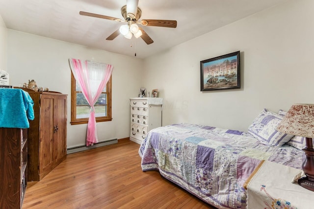 bedroom featuring a baseboard heating unit, ceiling fan, and light hardwood / wood-style flooring