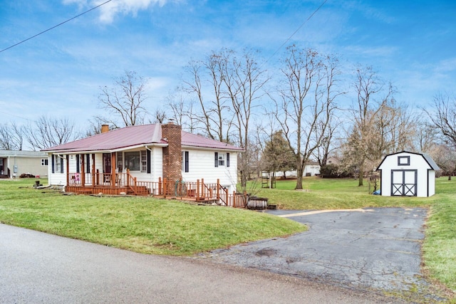 view of front of home featuring a front yard, a porch, and a storage unit