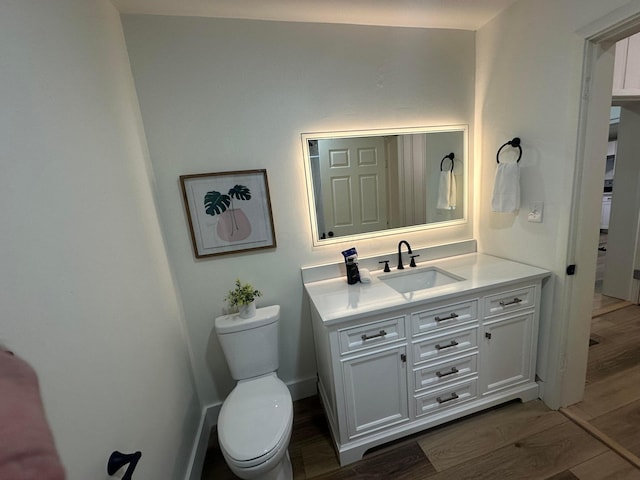 bathroom featuring hardwood / wood-style flooring, vanity, and toilet