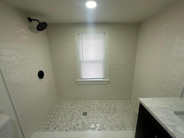 bathroom featuring vanity, toilet, and tiled shower