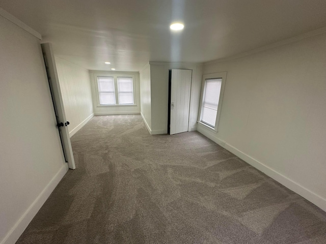 unfurnished room with crown molding and carpet floors