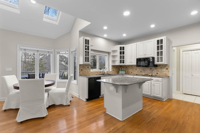 kitchen featuring a kitchen island, open shelves, a sink, black appliances, and white cabinets