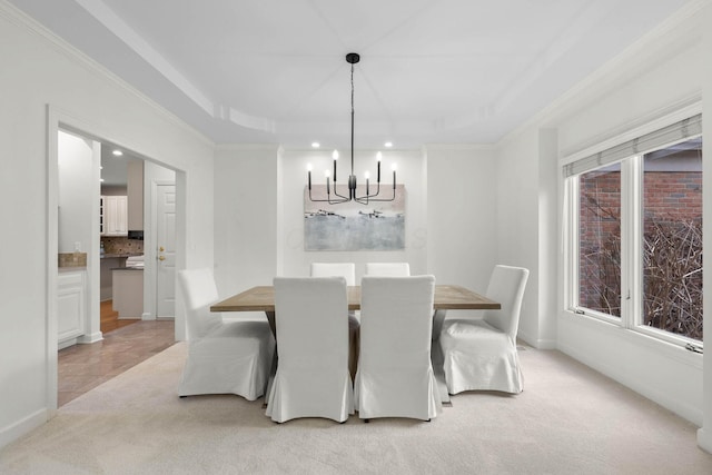 dining area with crown molding, light colored carpet, a raised ceiling, and a chandelier