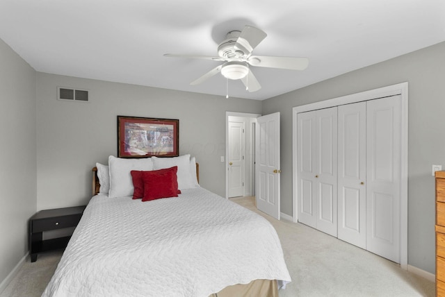 bedroom featuring light colored carpet, baseboards, visible vents, and a closet