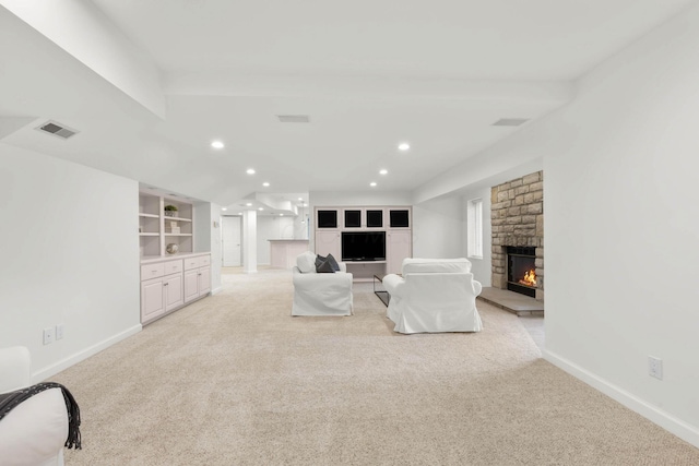 unfurnished living room with visible vents, baseboards, light carpet, recessed lighting, and a fireplace