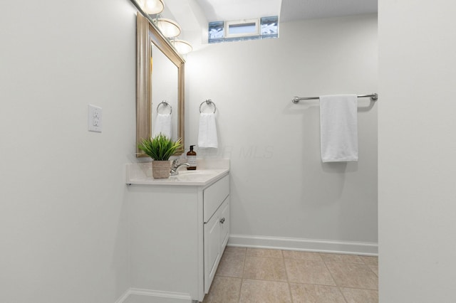 bathroom with baseboards, vanity, and tile patterned flooring