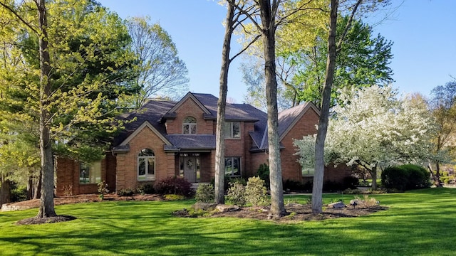 traditional home with brick siding and a front yard