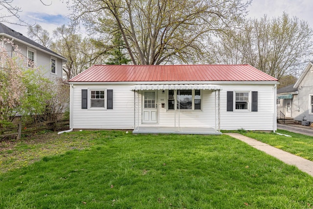 view of front of property with a front lawn, fence, and metal roof