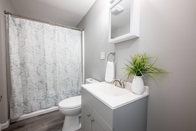 bathroom with toilet, a shower with shower curtain, vanity, and wood finished floors