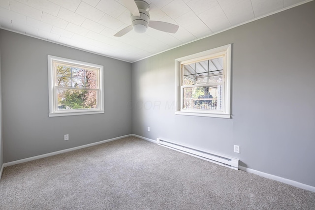 carpeted spare room with baseboards, a ceiling fan, baseboard heating, and ornamental molding