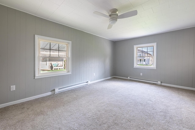 carpeted spare room featuring a baseboard heating unit and ceiling fan
