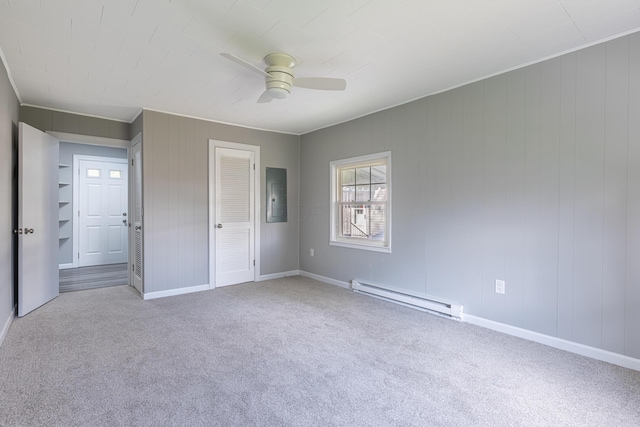 unfurnished bedroom with electric panel, baseboard heating, baseboards, and carpet