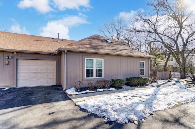 view of snow covered exterior with a garage