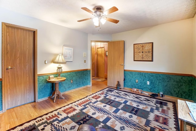 interior space featuring ceiling fan, a textured ceiling, and light wood-type flooring