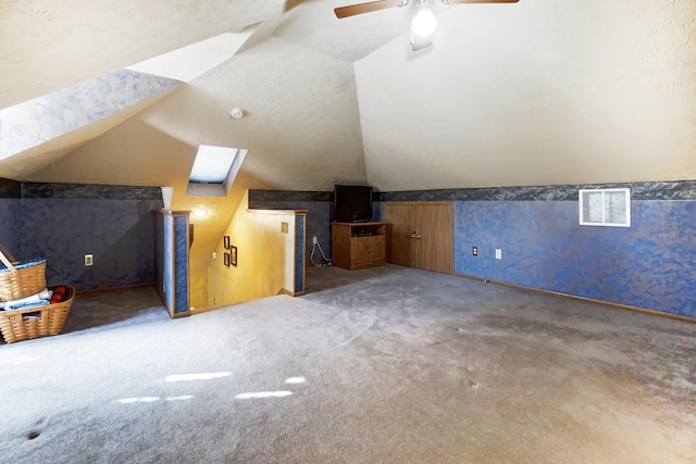 bonus room featuring lofted ceiling with skylight, carpet floors, and ceiling fan