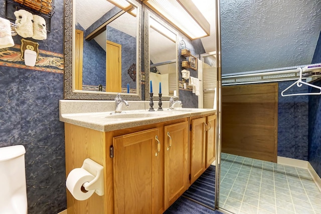 bathroom with vanity, toilet, tile patterned flooring, and a textured ceiling